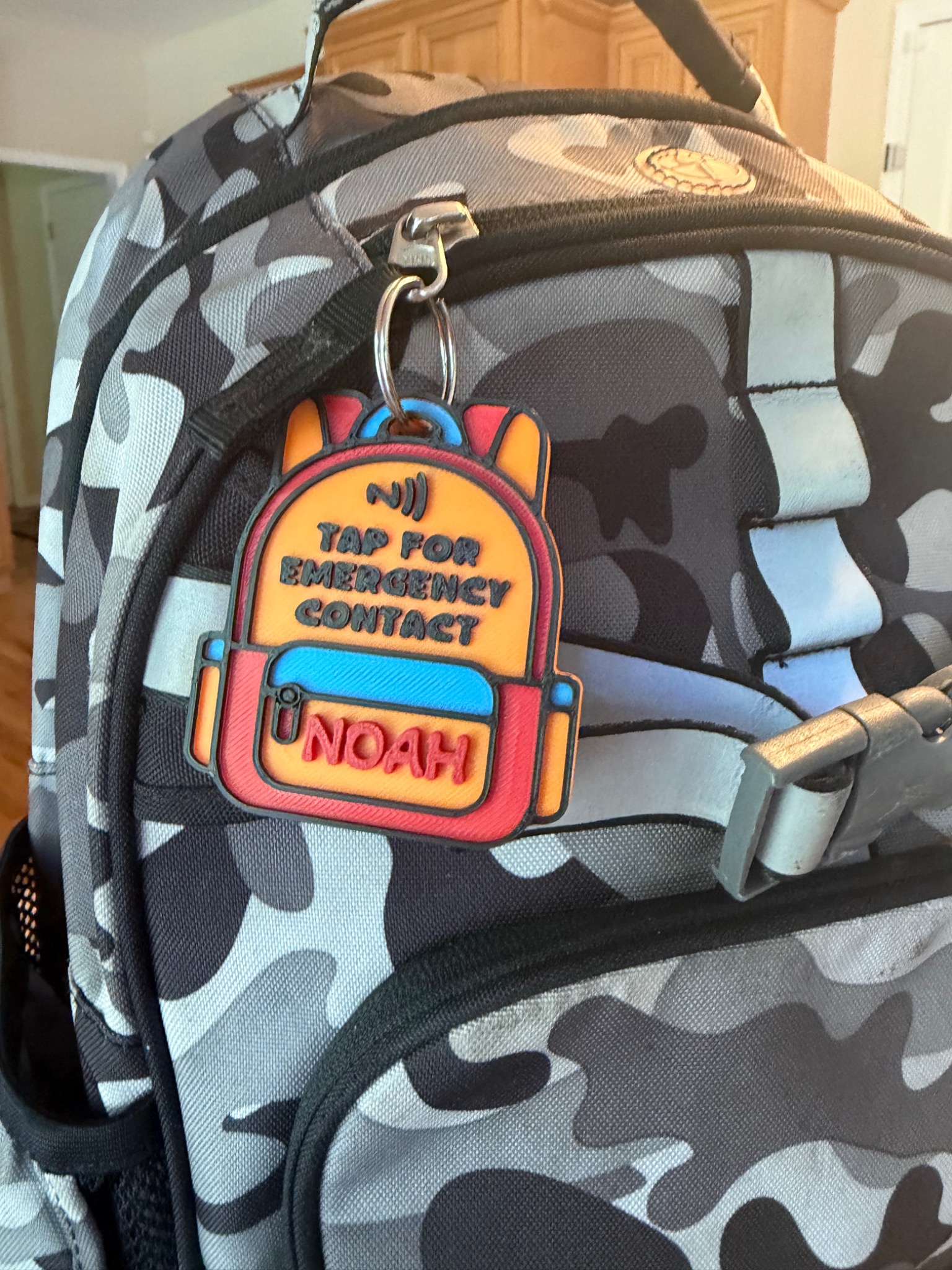 Personalized Fireside Prints NFC emergency contact tag attached to a backpack